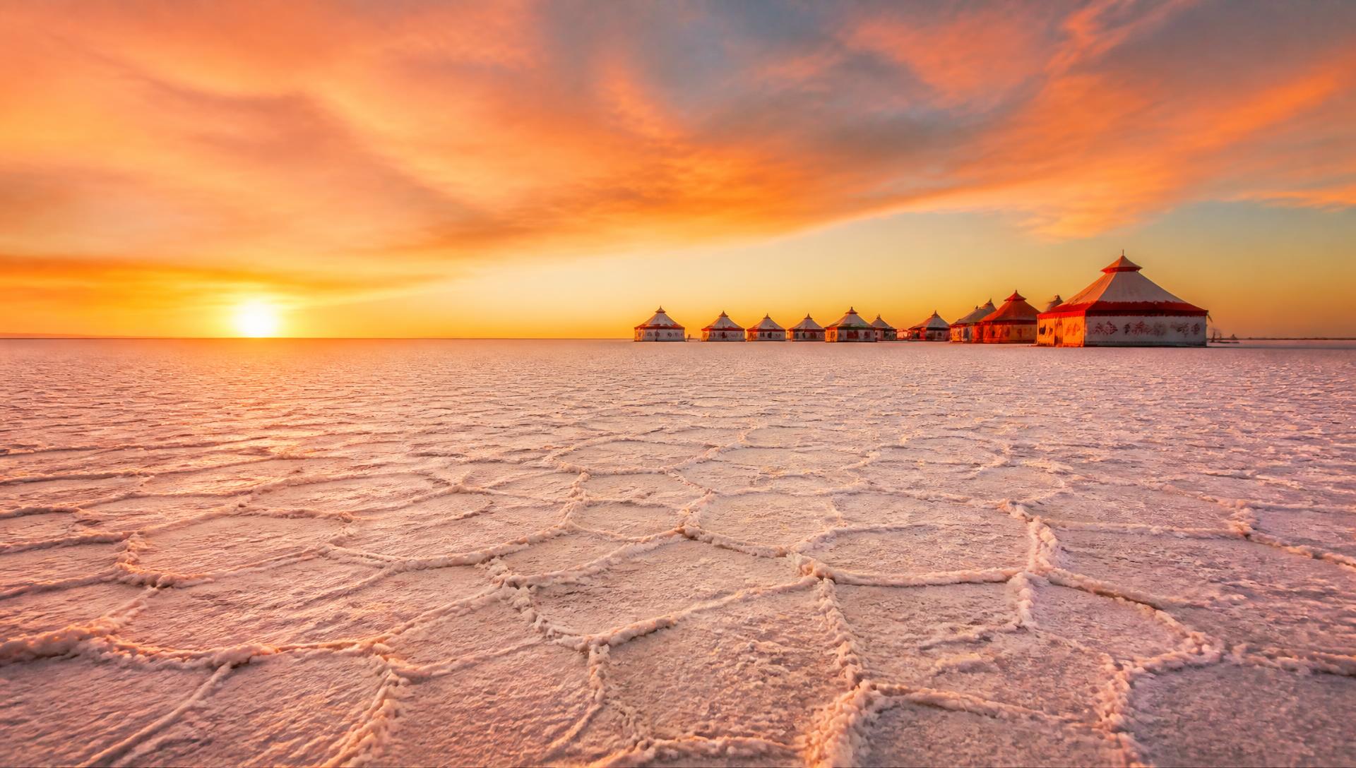 White Rann of Kutch at sunset with traditional tents on the horizon
